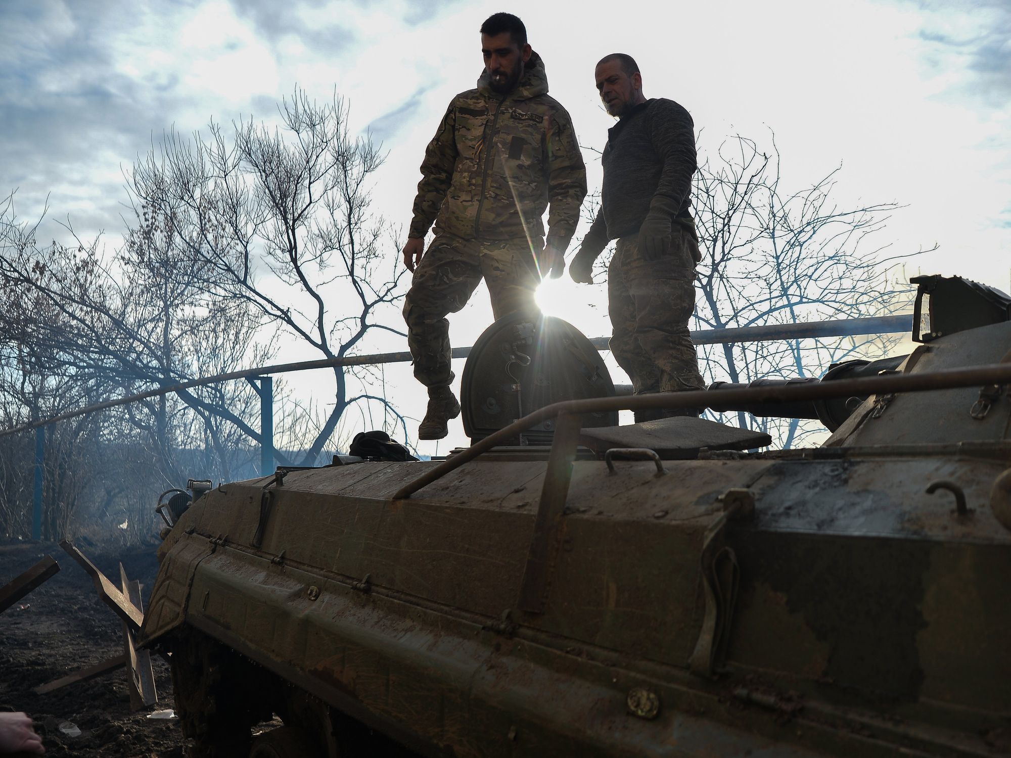 Ukrainian BMP crew, stands on top of their vehicle outside the city of Avdiivka.