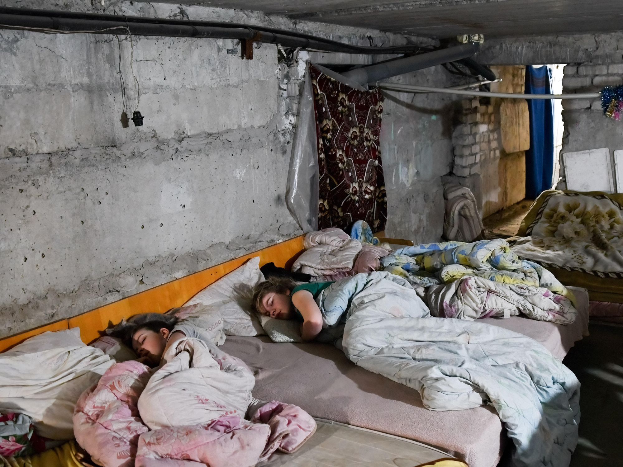 Ukrainian civilians sleeping in the basement under their apartment building in Sviatohirsk.​