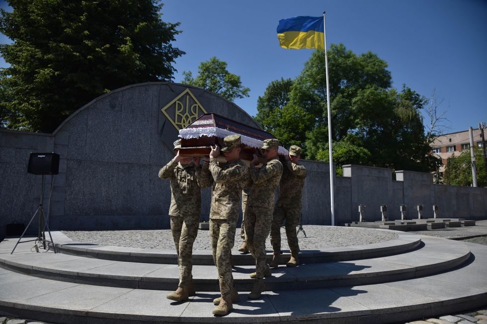 Ukrainian military carry the coffin with the body during the farewell ceremony of a fallen soldier.