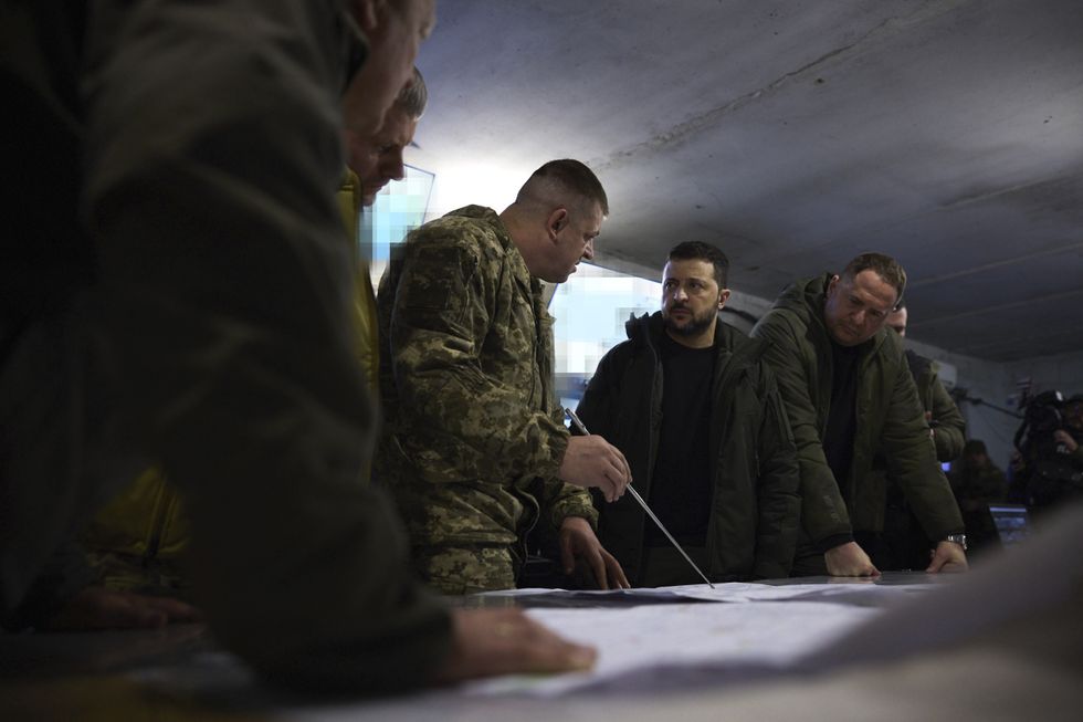Ukrainian President Volodymyr Zelenskyy, center, is briefed on the frontline situation by Donetsk Operational and Tactical Group, Brig. Gen.