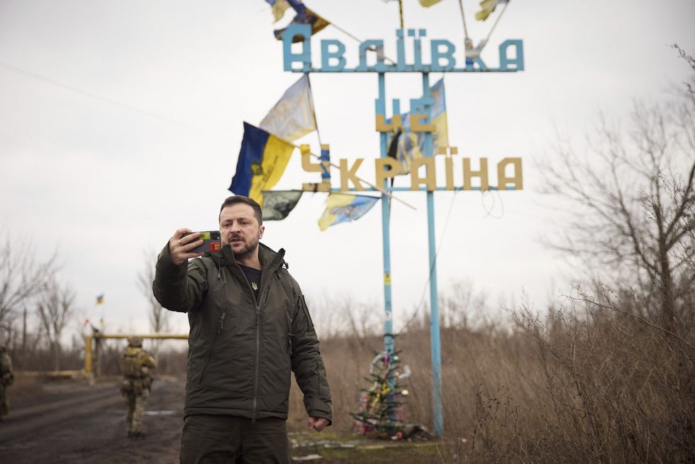 Ukrainian President Volodymyr Zelenskyy recording a frontline video address for his nation, in front of the sign 'Avdiivka is Ukraine'.