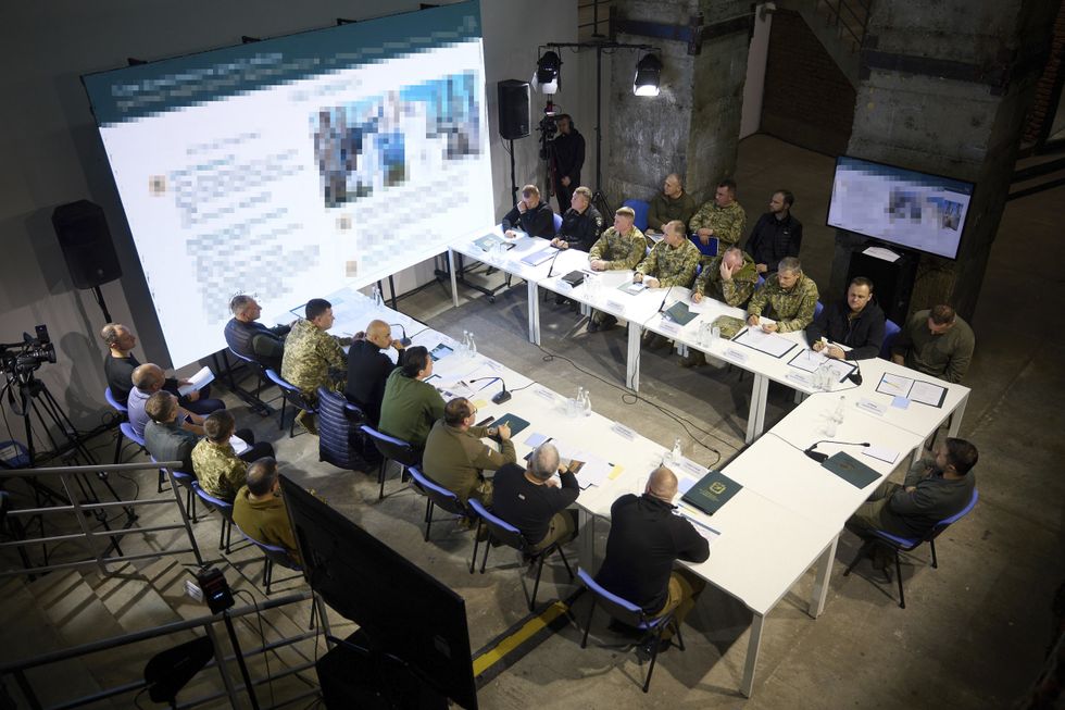Ukrainian President Volodymyr Zelenskyy, right, chairs a meeting on preparing for winter conditions with members of the government during a visit to the frontlines, October 3, 2023 in Kharkiv, Ukraine.