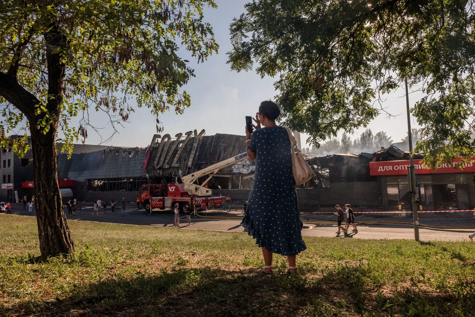 Ukrainian rescuers spray water on a supermarket destroyed as a result of a rocket hitting Odessa, Ukraine.