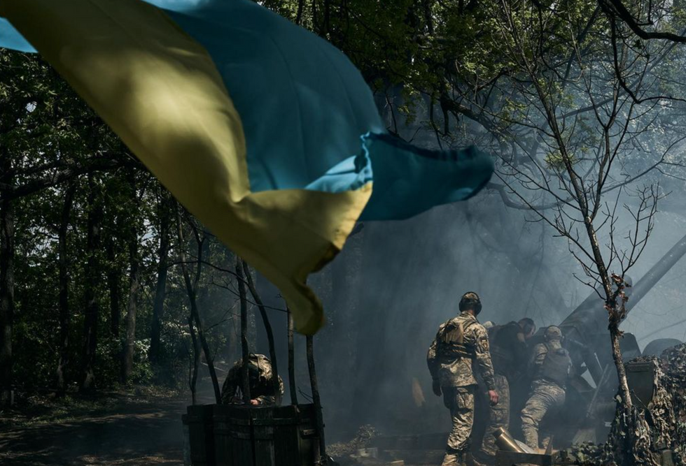 Ukrainian soldiers beneath the country's flag.