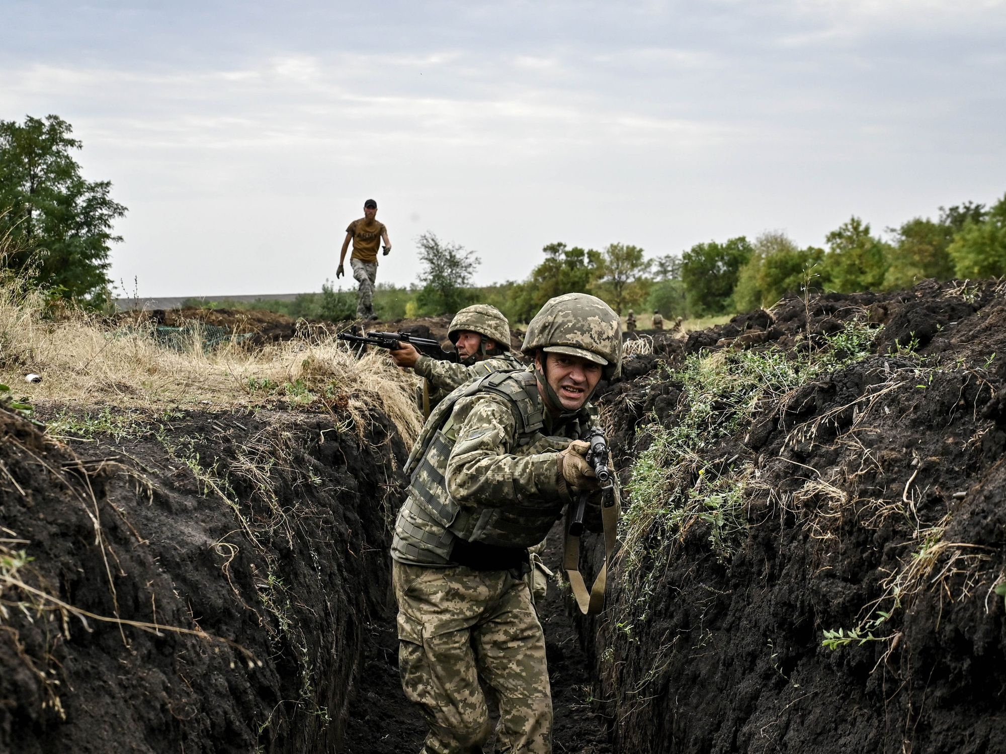 Ukrainian soldiers run through trenches