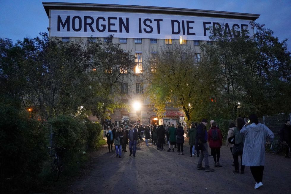 Visitors stand in a queue in front of the Berghain in the evening, Berlin