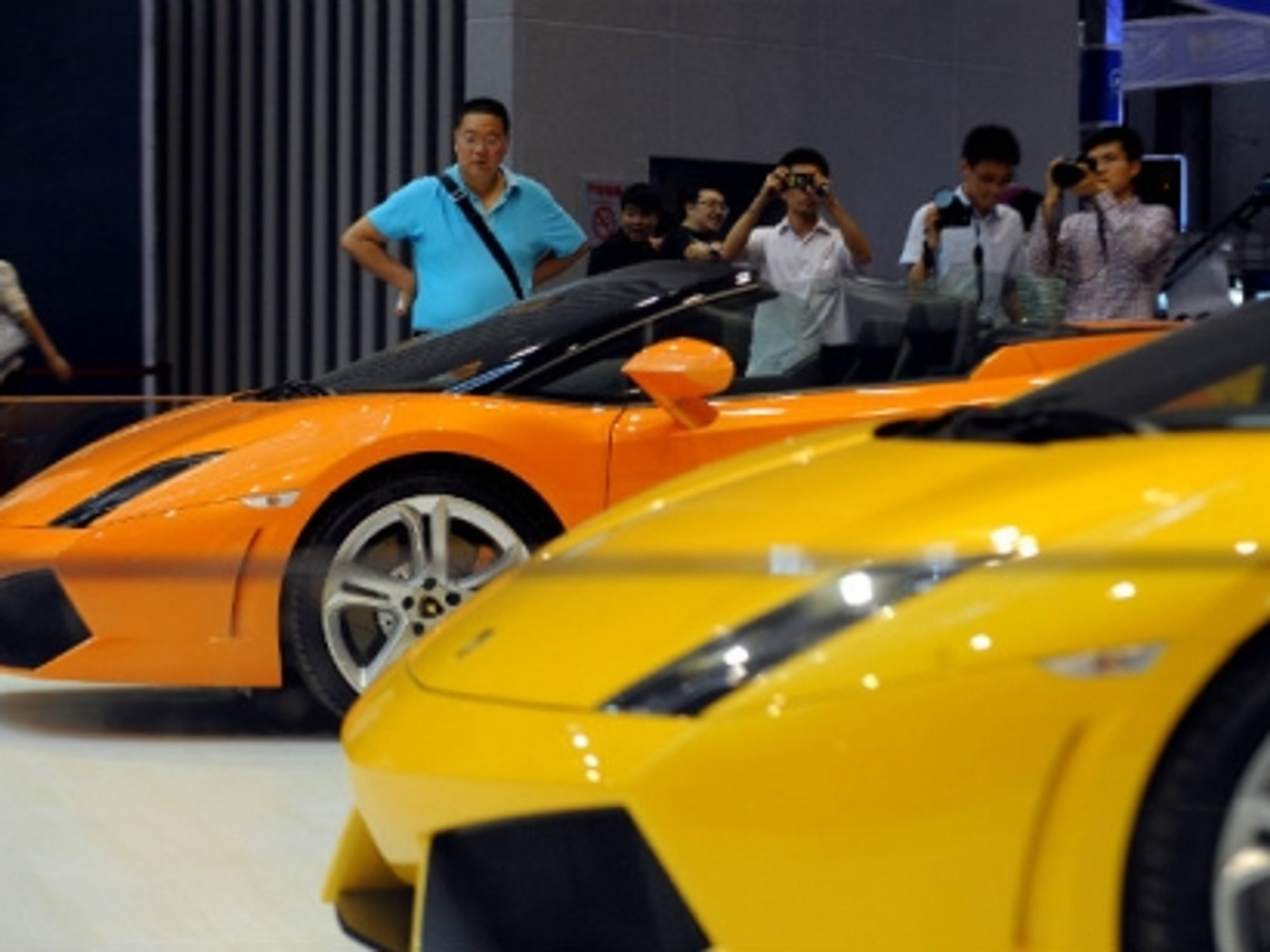 Visitors view Lamborghini sports cars at the 2013 International Automobile Exhibition in Taiyuan.