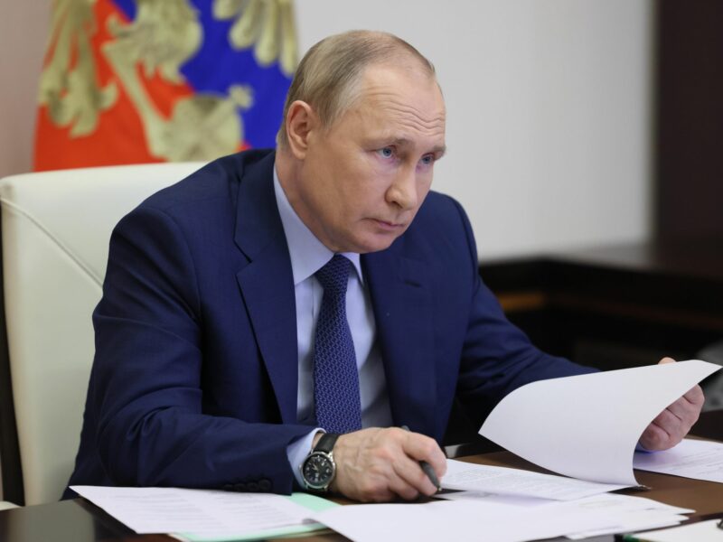 Vladimir Putin at a desk going through paper documents