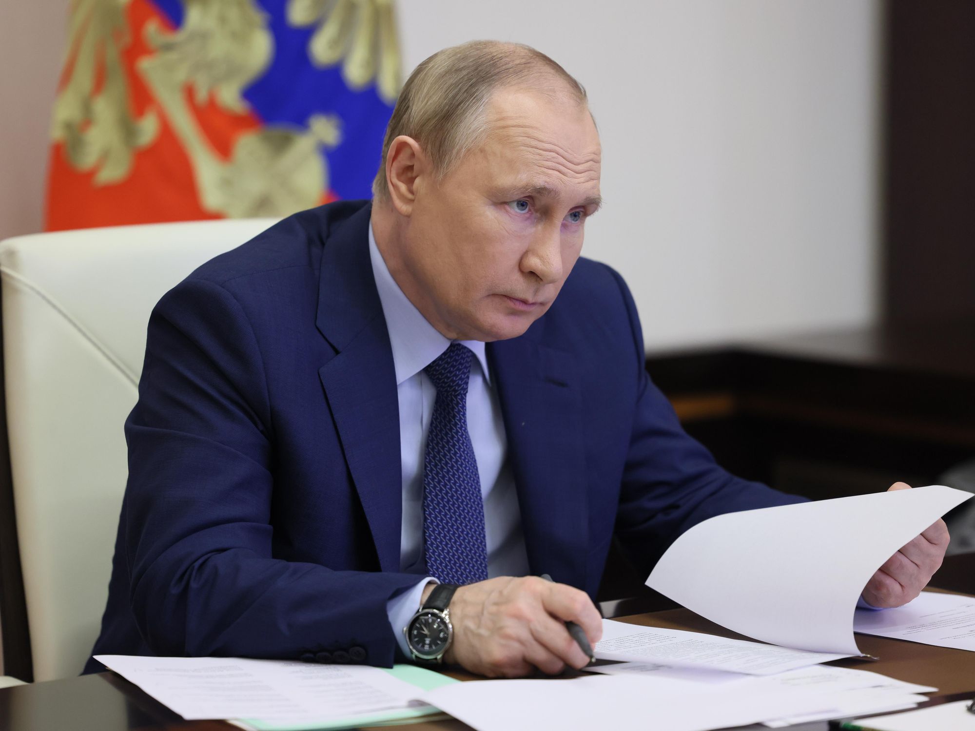 Vladimir Putin at a desk going through paper documents