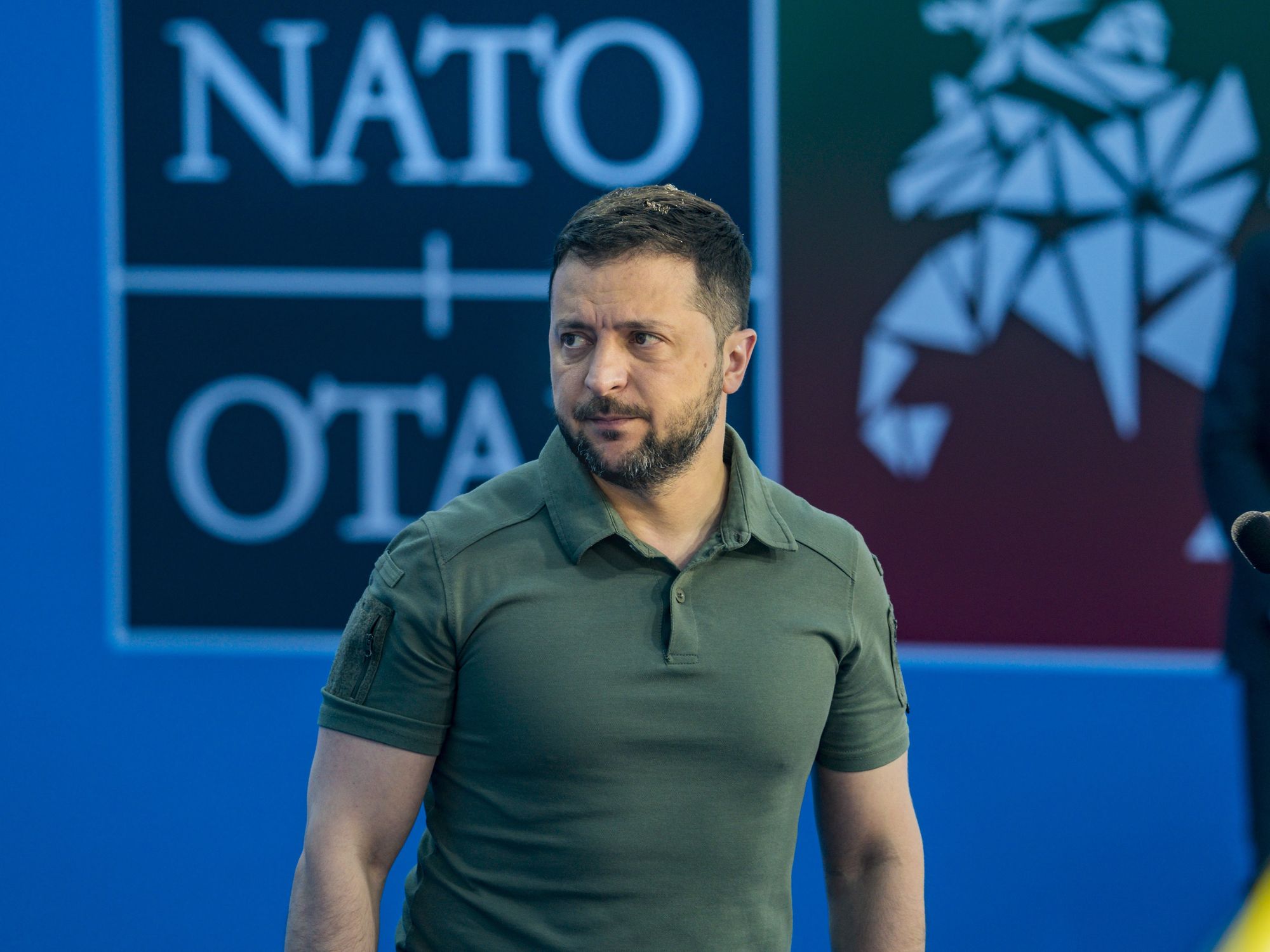 Volodymyr Zelenskiy in front of a NATO backdrop