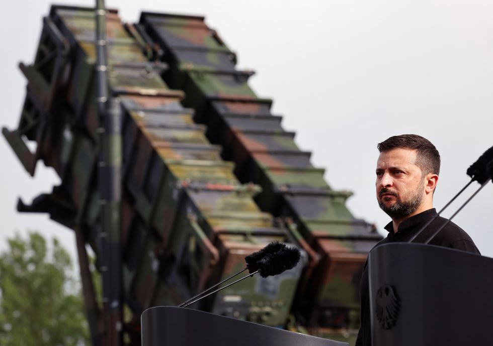 Volodymyr Zelenskyi, President of Ukraine, stands in front of a Patriot air defense missile system during his visit to a military training area.