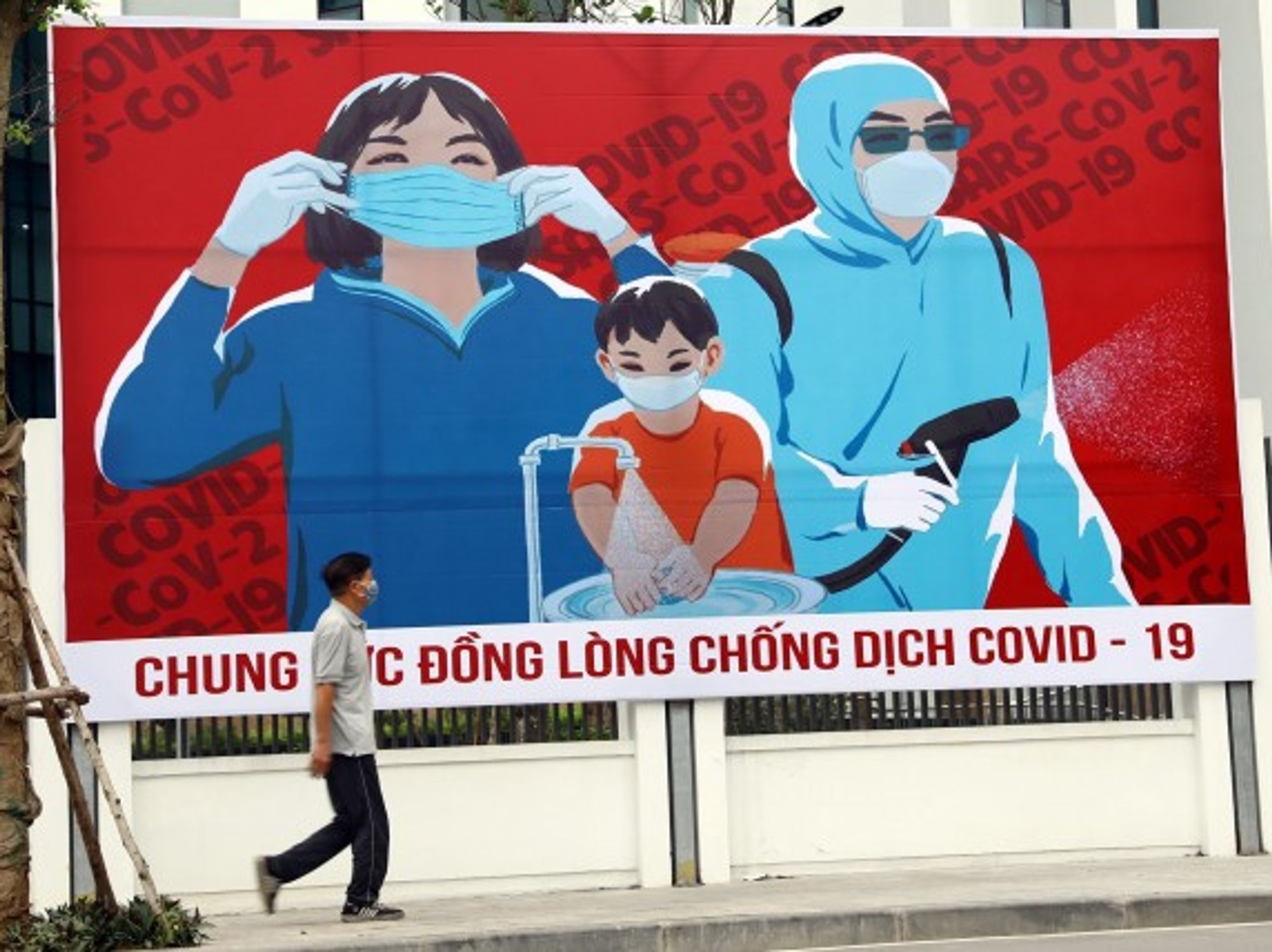 Waking past a billboard in Hanoi, Vietnam, on April 1
