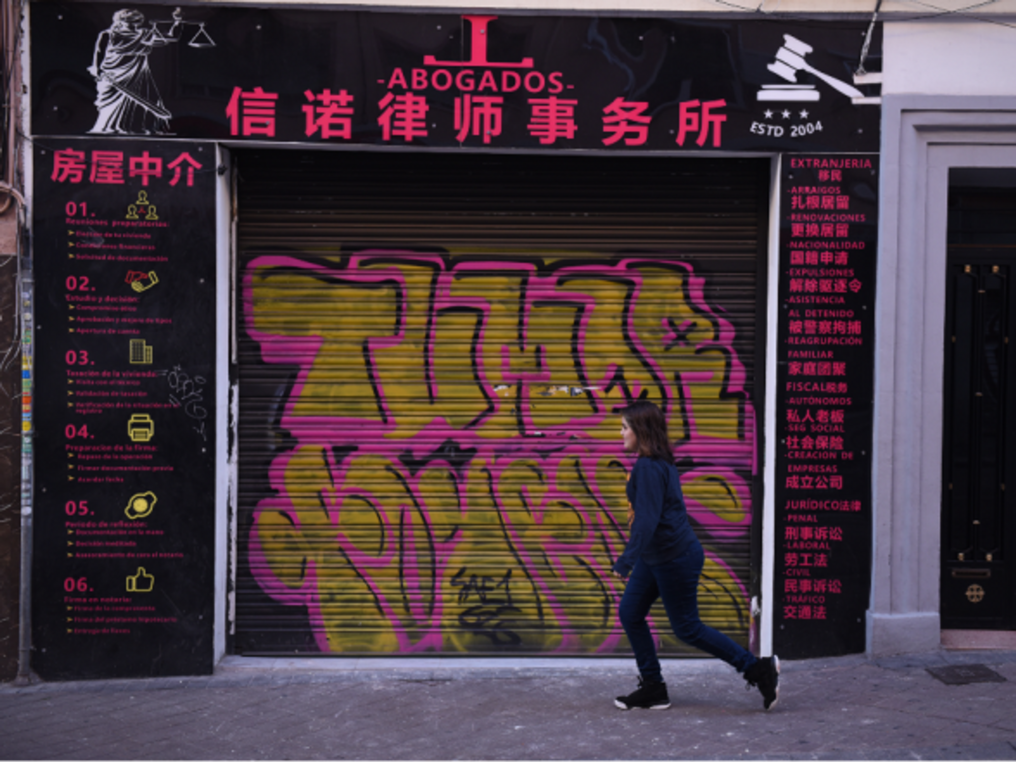 Walking past a closed Chinese shop in Madrid's Usera district