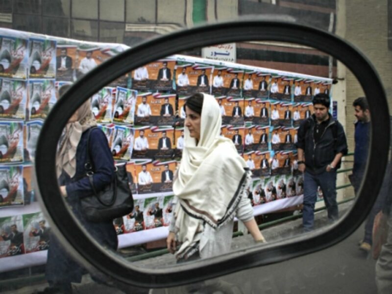 Walking past electoral posters in Tehran on Feb. 22