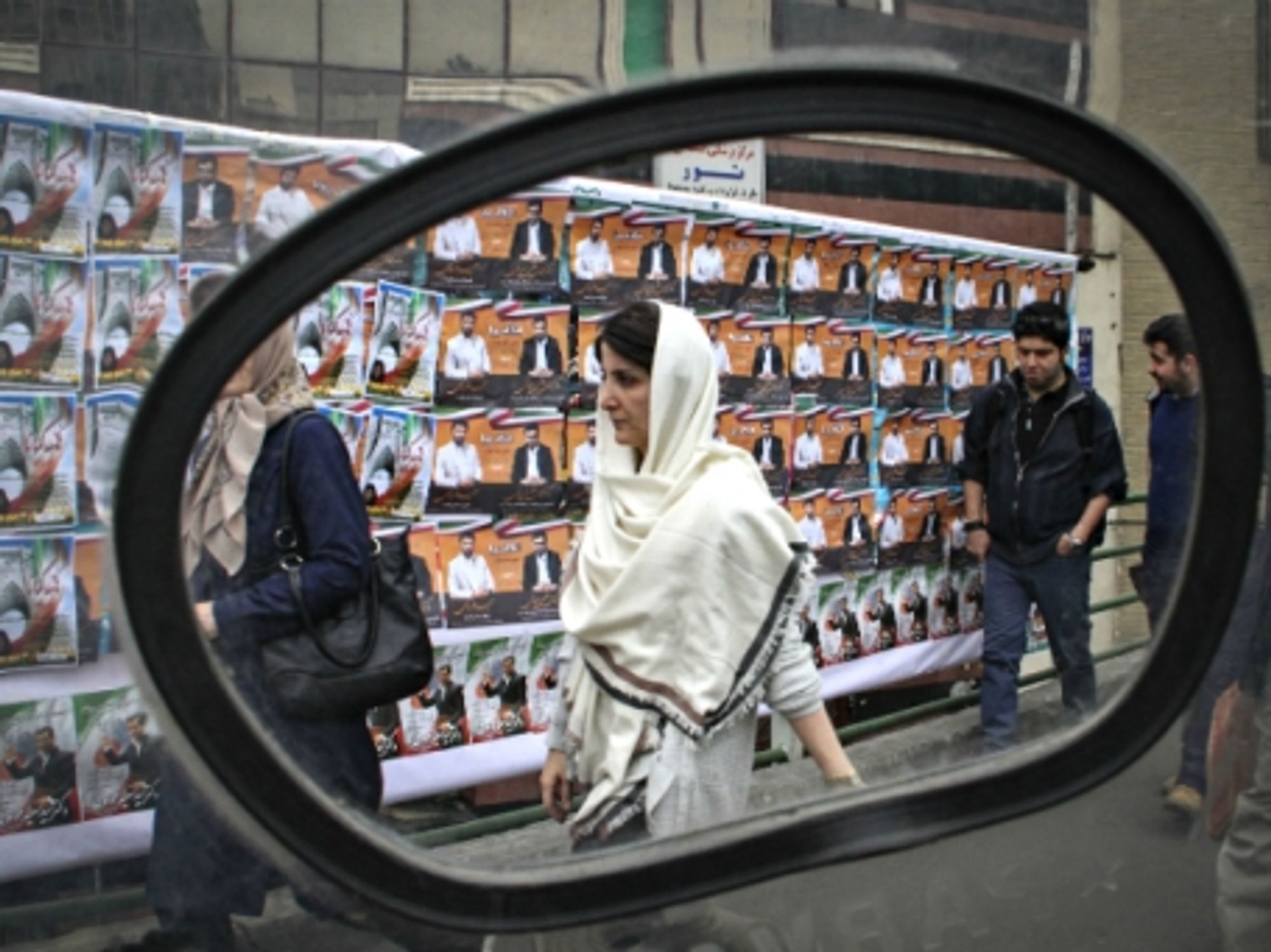 Walking past electoral posters in Tehran on Feb. 22