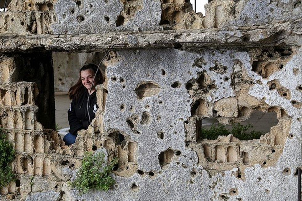 Woman at the ruins of a building