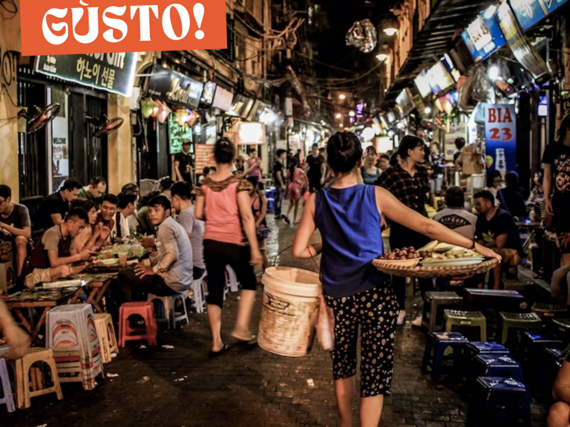 Woman carrying braided tray and white bucket while walking on a street market in Hanoi, Vietnam.