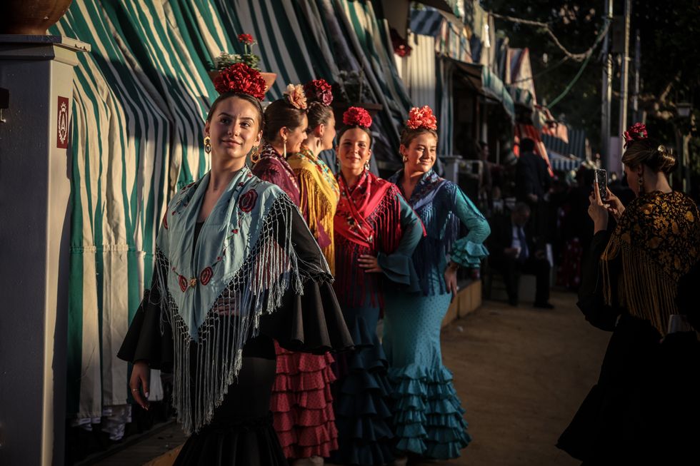 Woman celebrating Feria de Abril de Sevilla 2023 with outfits inspired by the architect Anü­bal Gonzü¡lez and Alvarez Ossorio and the Teatro Coliseo Espana