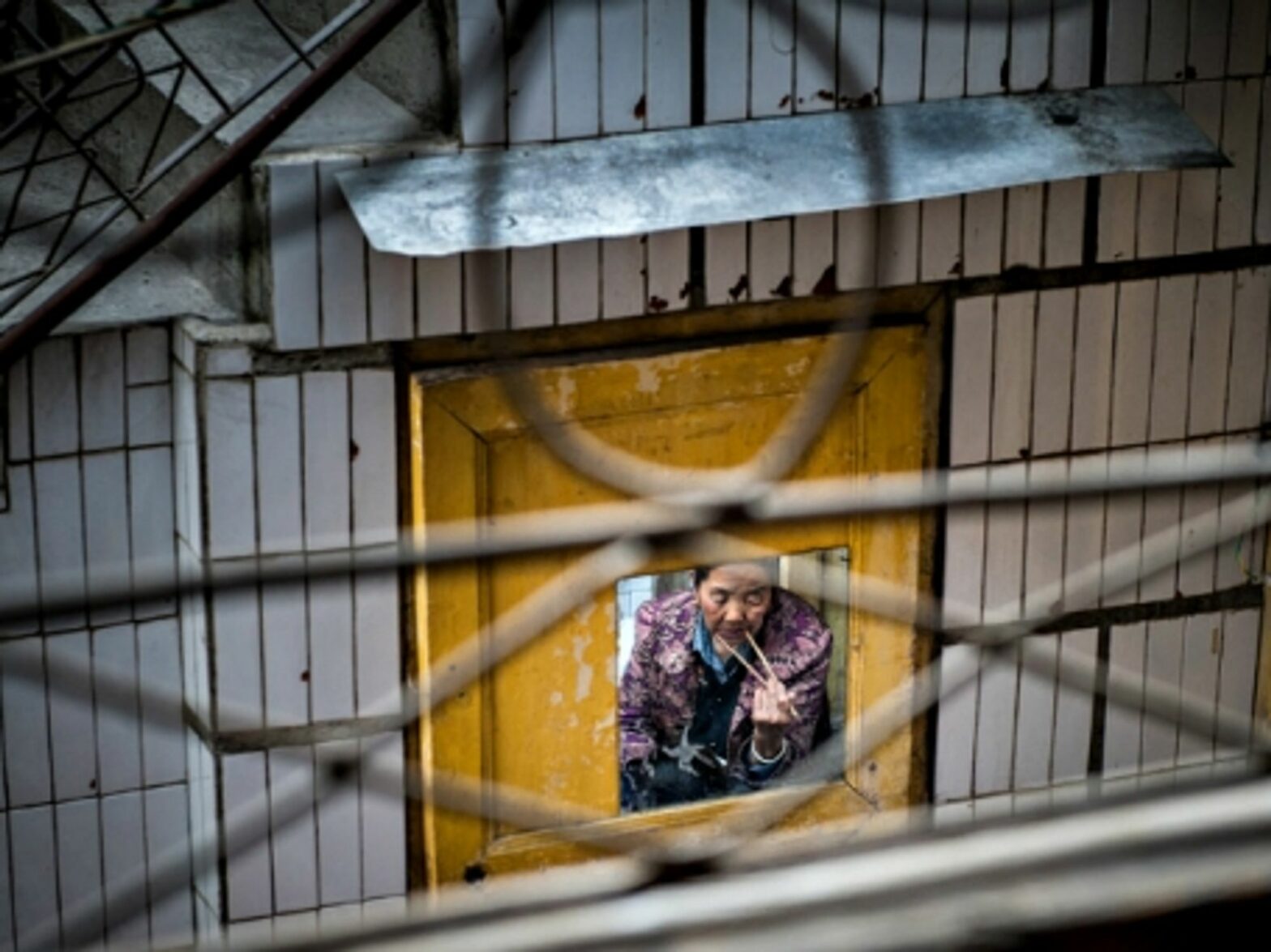 Woman eating with chopsticks in Songpan county, China