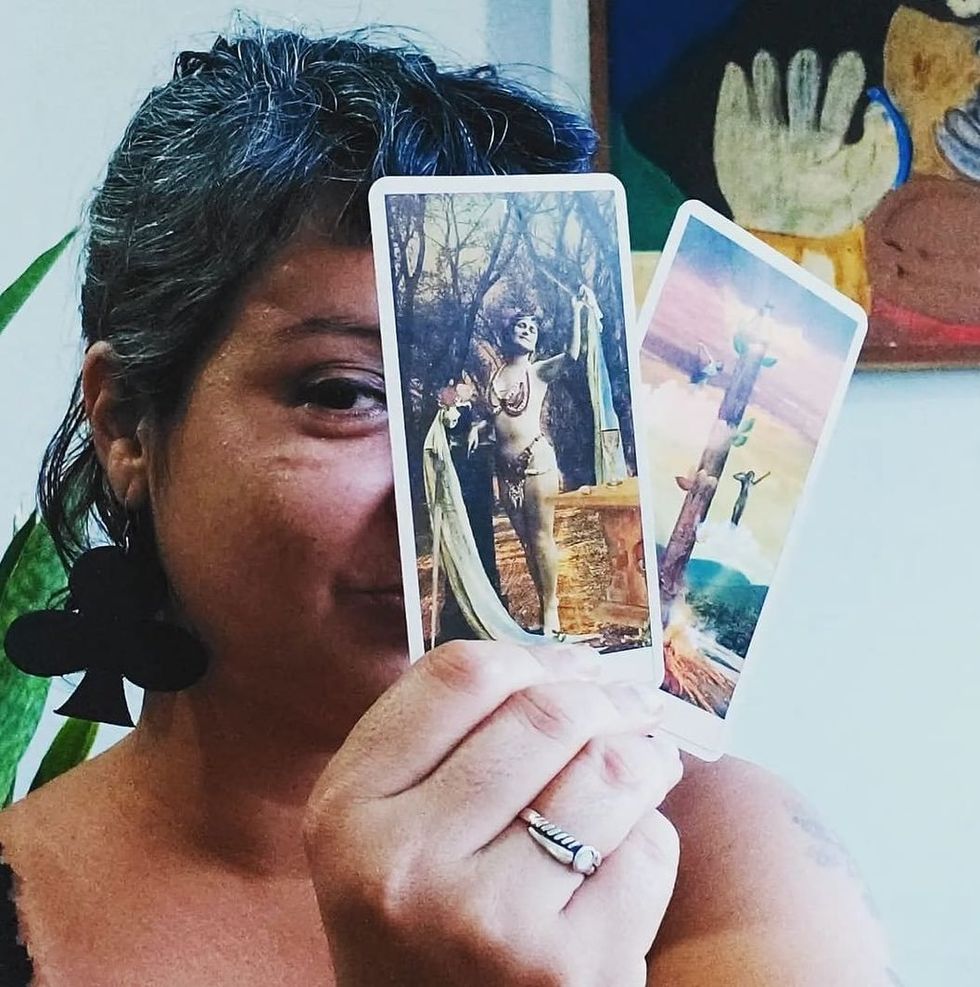 Woman holding tarot cards.