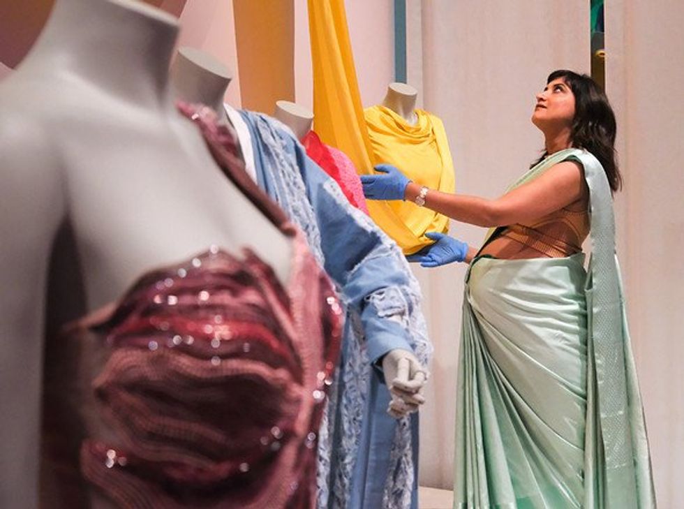 Woman looking at a contemporary sari at The Offbeat Sari exhibition at the Design Museum, London, UK.