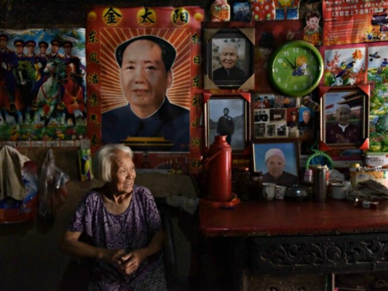 Woman under a portrait of Mao in Yuncheng, China