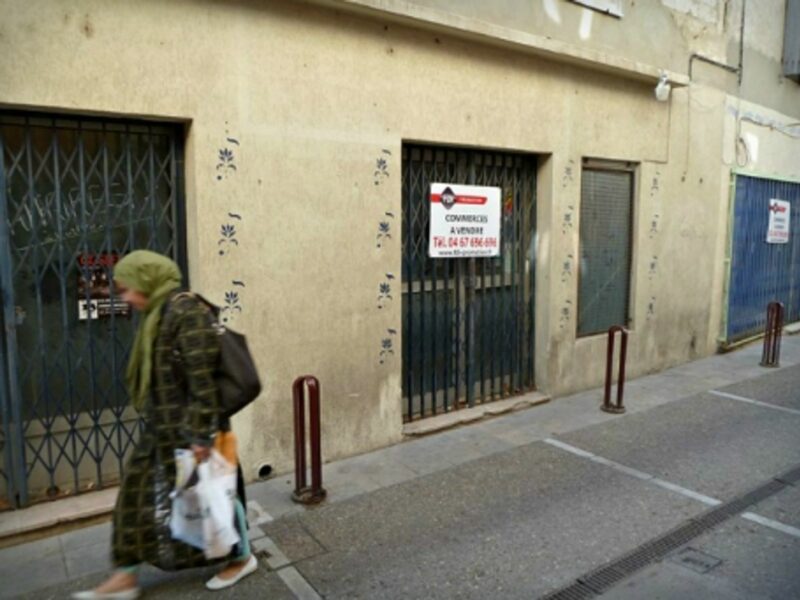 Woman walking in an empty street in Lunel, southern France