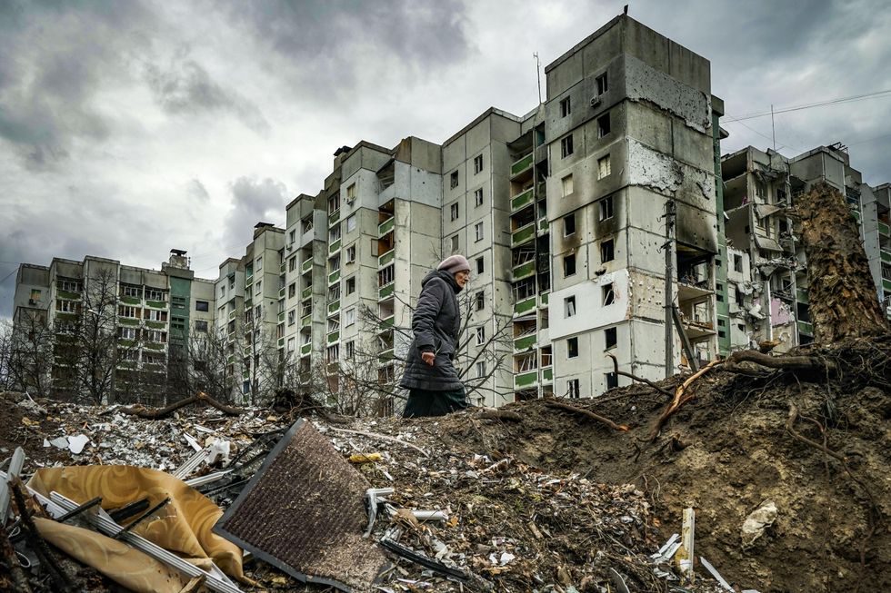 Woman walking in ruins in Chernihiv, Ukraine.