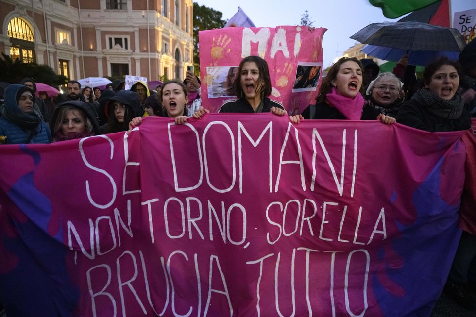 Women screaming in the street of Messina holding up pink banners for the fight against femicide. The banner in front reads 'If I don't come back tomorrow, sister, burn everything'.