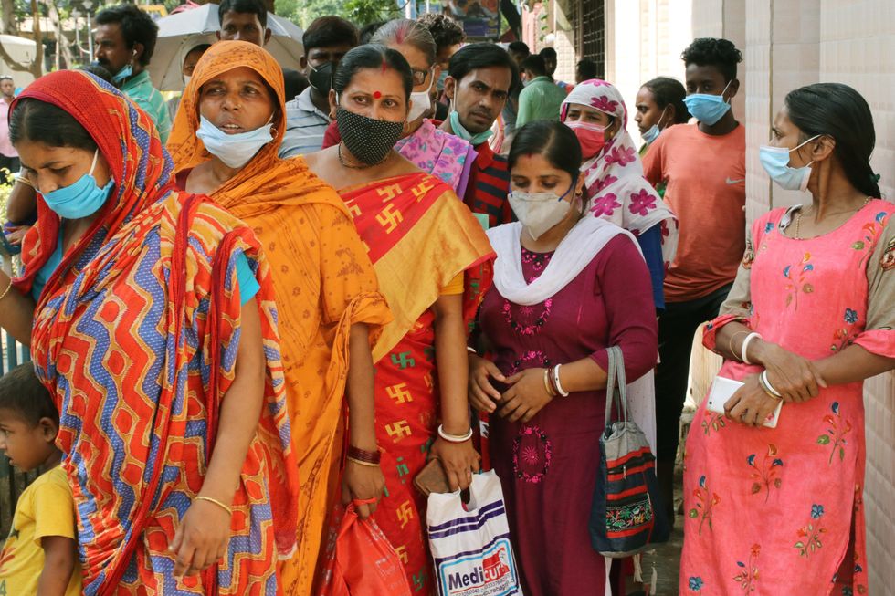 Women waiting to receive a dose of COVISHIELD vaccine against COVID-19 in Kolkata, India