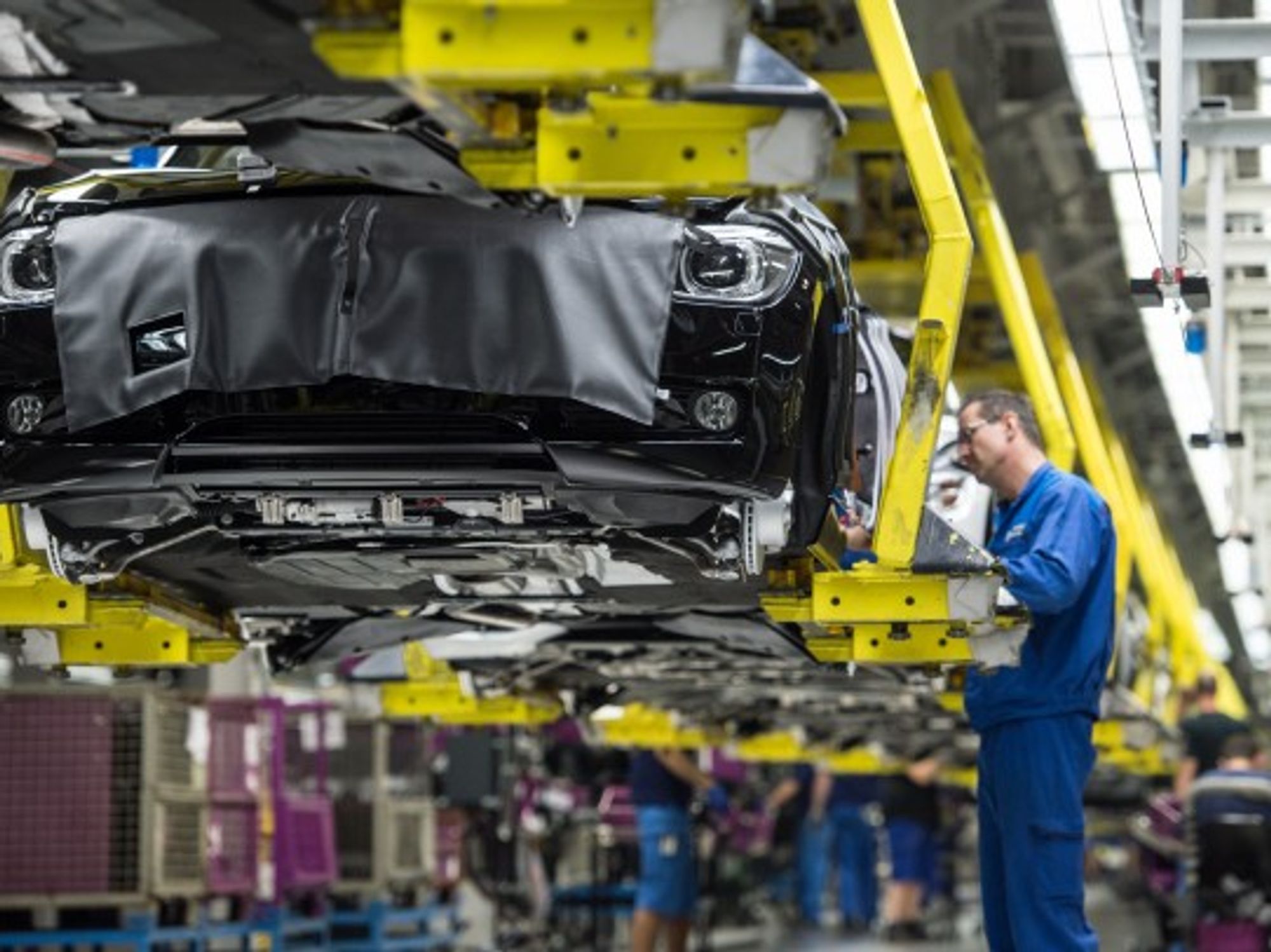 Workers assemble cars at a BMW factory in Germany. Some believe that technological progress has stagnated.