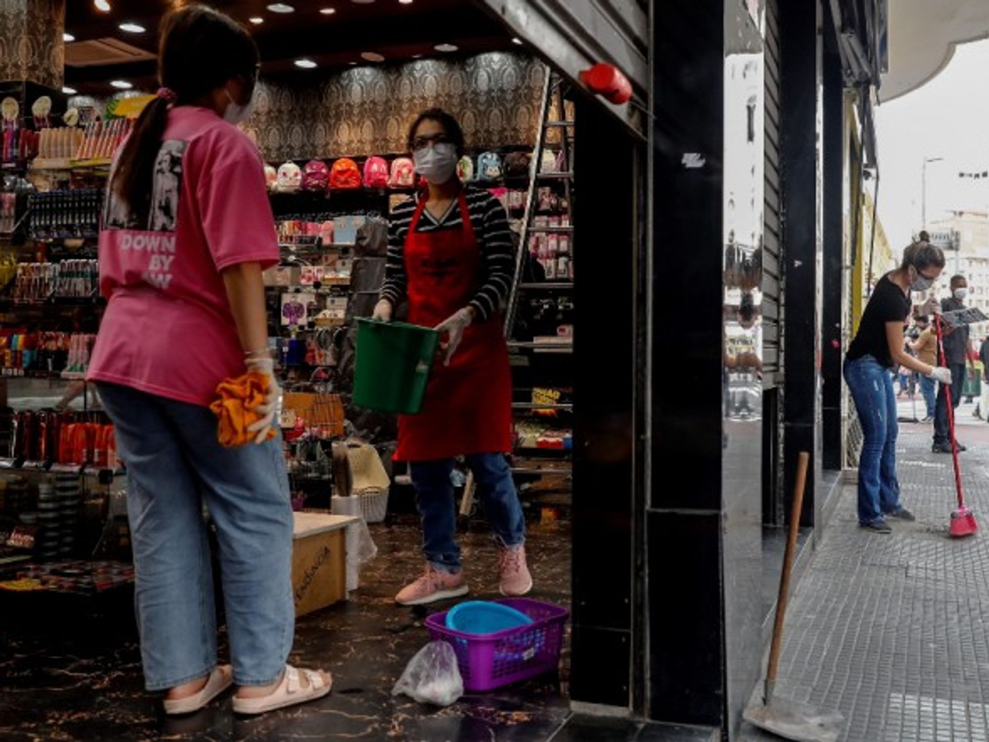 Workers clean a shop before opening in Sao Paulo
