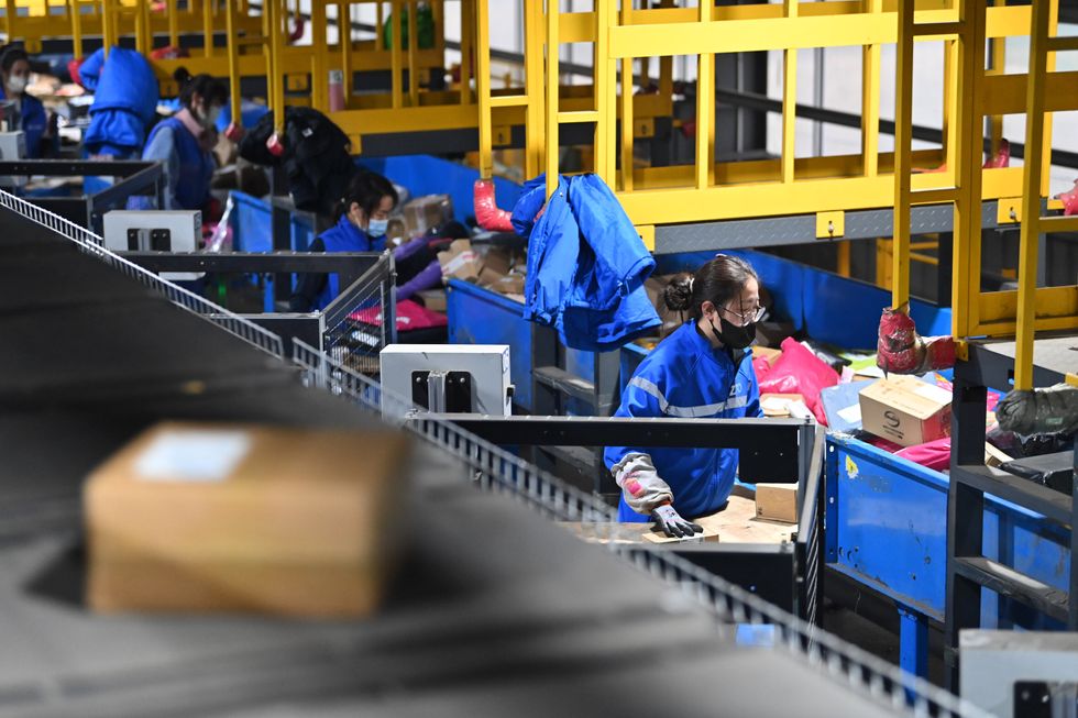 Workers sort packages at a logistics center in Taiyuan.