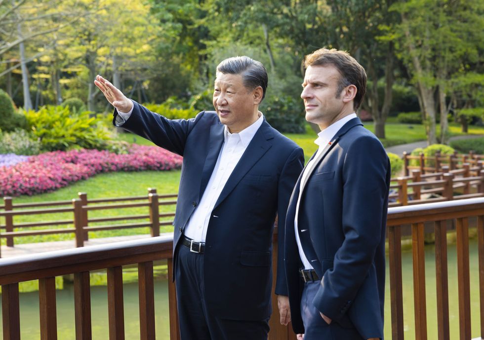 Xi Jinping pointing to something as he talks to Emmanuel Macron