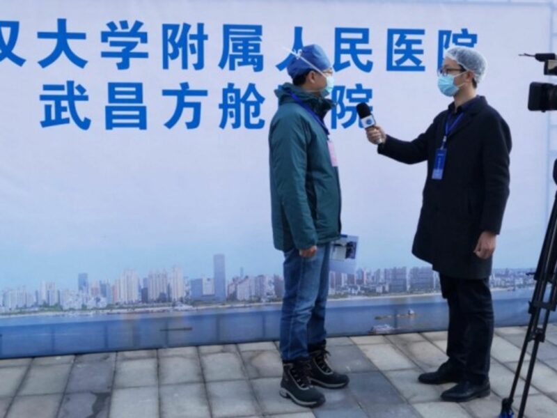 Xinhua News Agency journalist Liang Jianqiang makes an interview at a temporary hospital in Wuhan.
