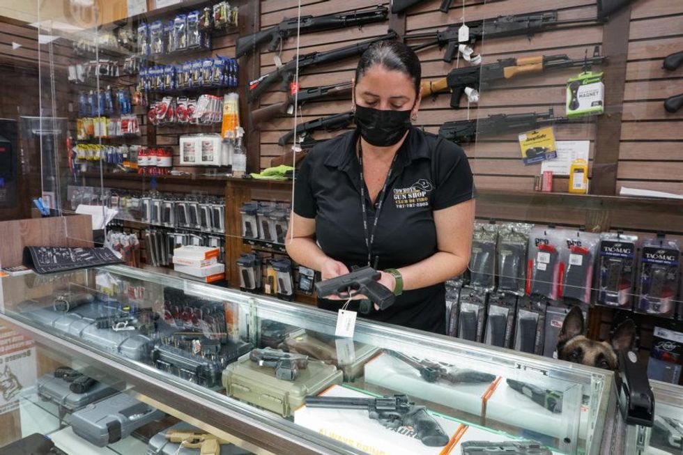 Yomara Adrovet, owner of a gun shop and shooting range in Bayamón, Puerto Rico, practices target shooting at her store.​