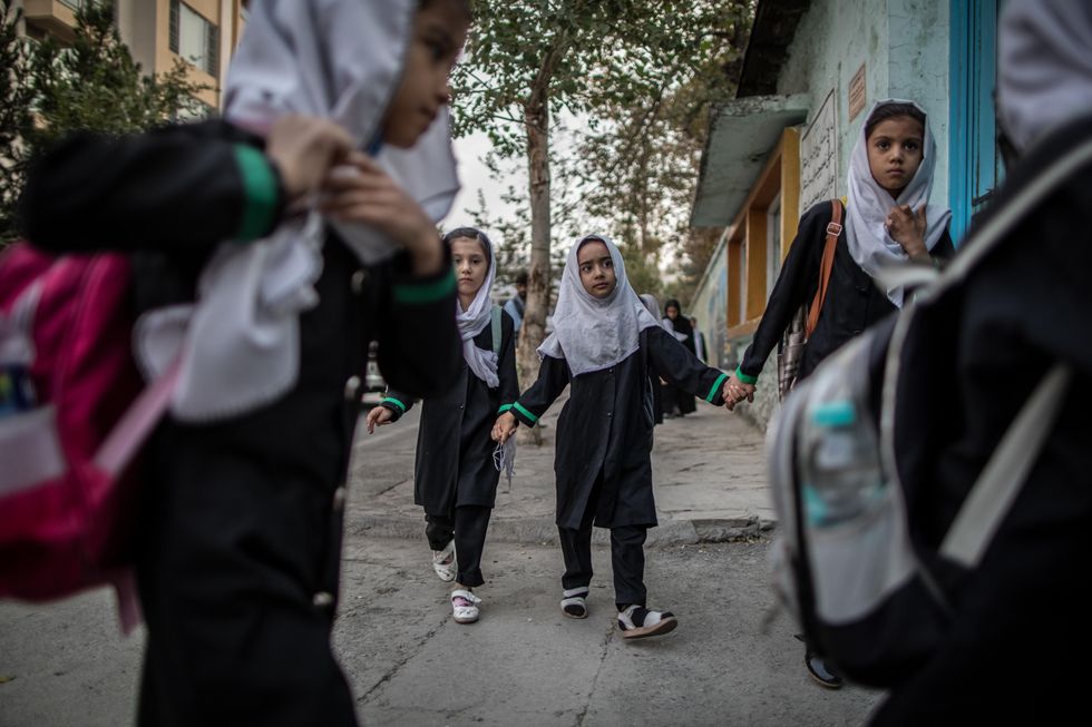 Young girls arrive to a primary school in Kabul. The Taliban government has banned girls from secondary school education and allowed schools to reopen for boys only.