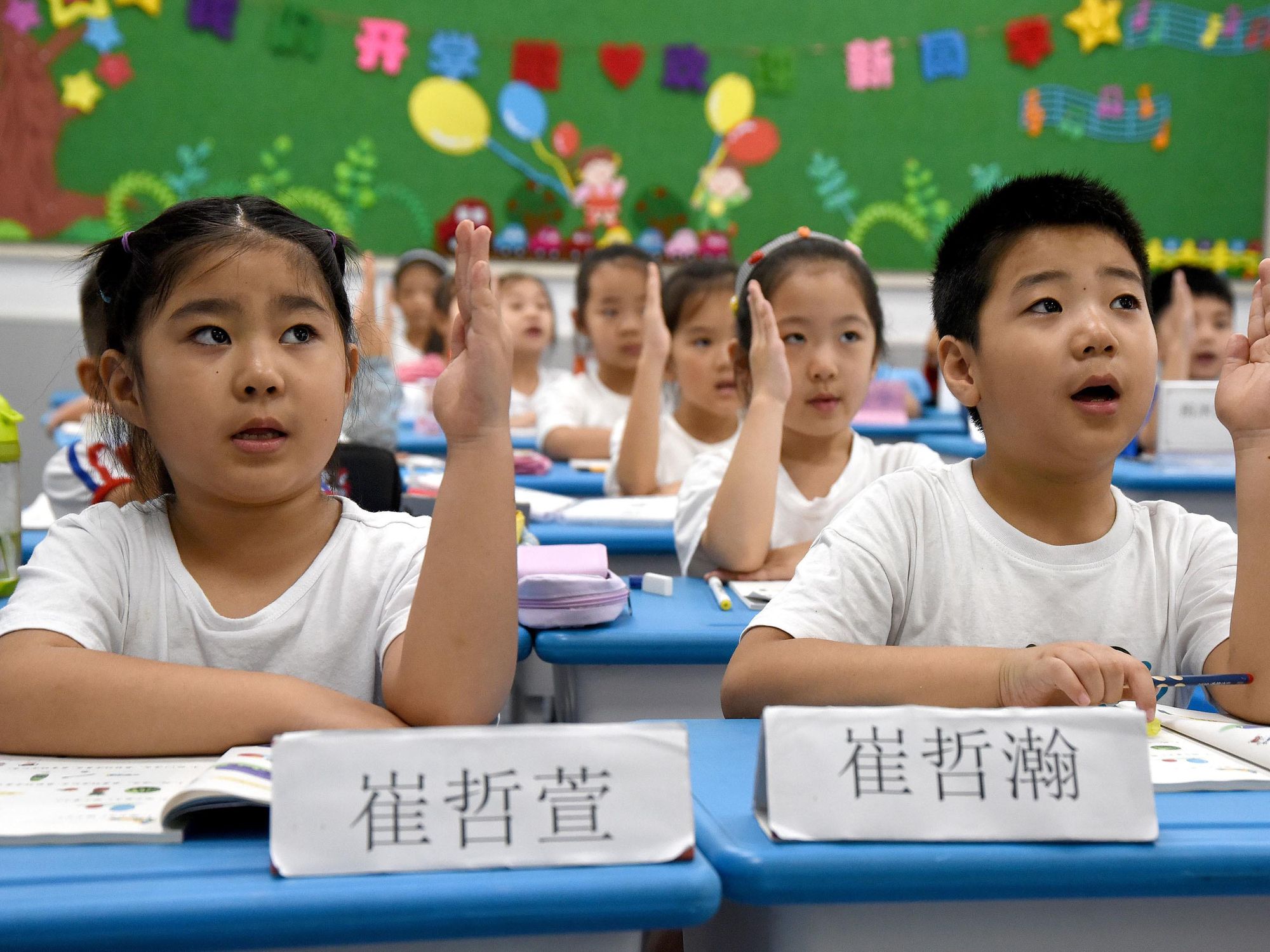 young students in China holding up their hands
