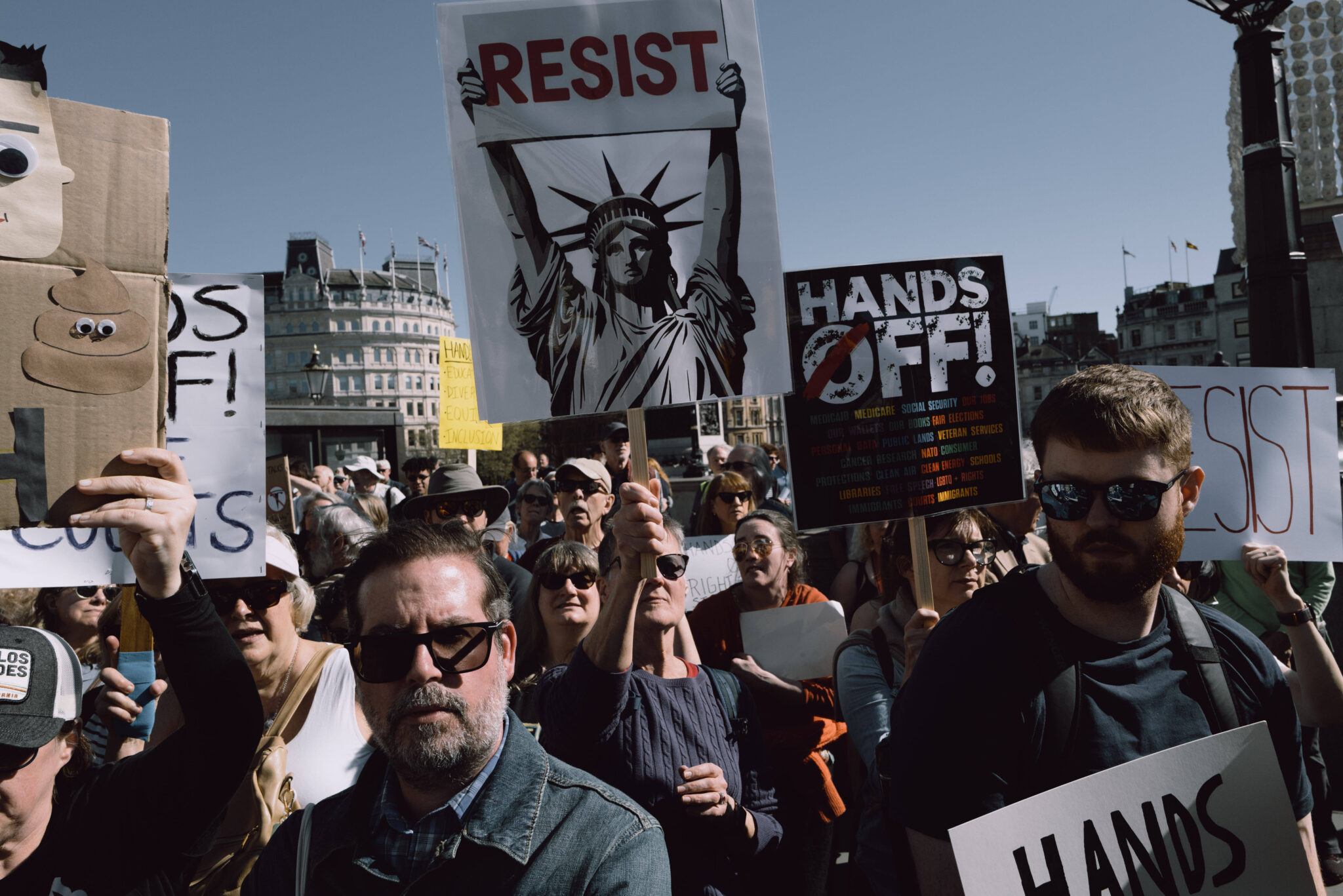 A crowd in London holds signs protesting Donald Trump