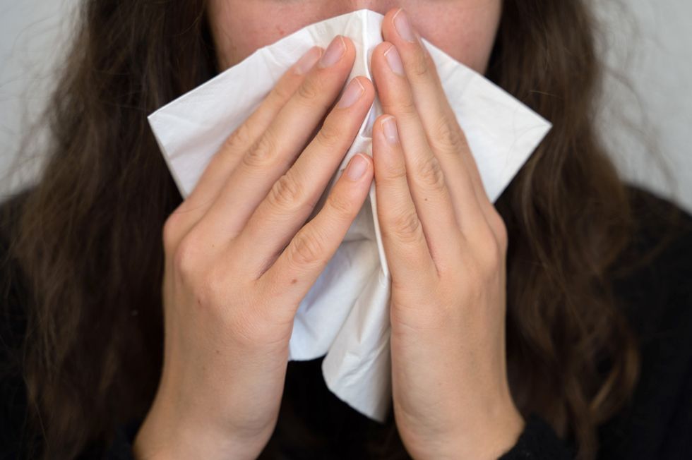 A woman blows her nose.