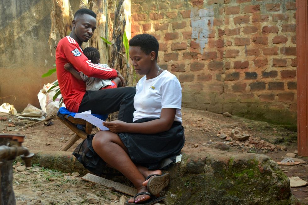 Barbara Kwarikunda reviews documents obtained from Cleveland Specialized Clinic in Kasangati at their home in Kampala.