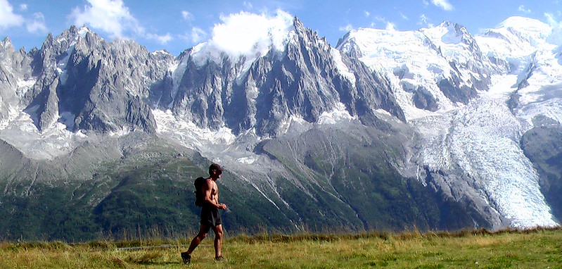 A man walks in front of mountains