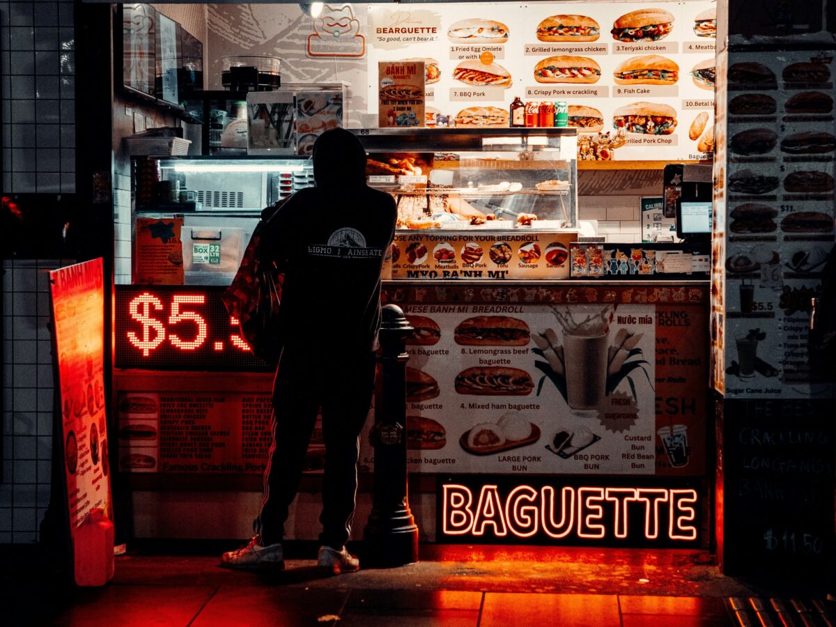 A person orders a bahn mi at a late night sandwich shop