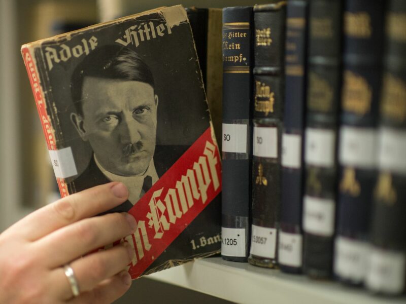 Photo of a hand picking up a copy of Mein Kampf