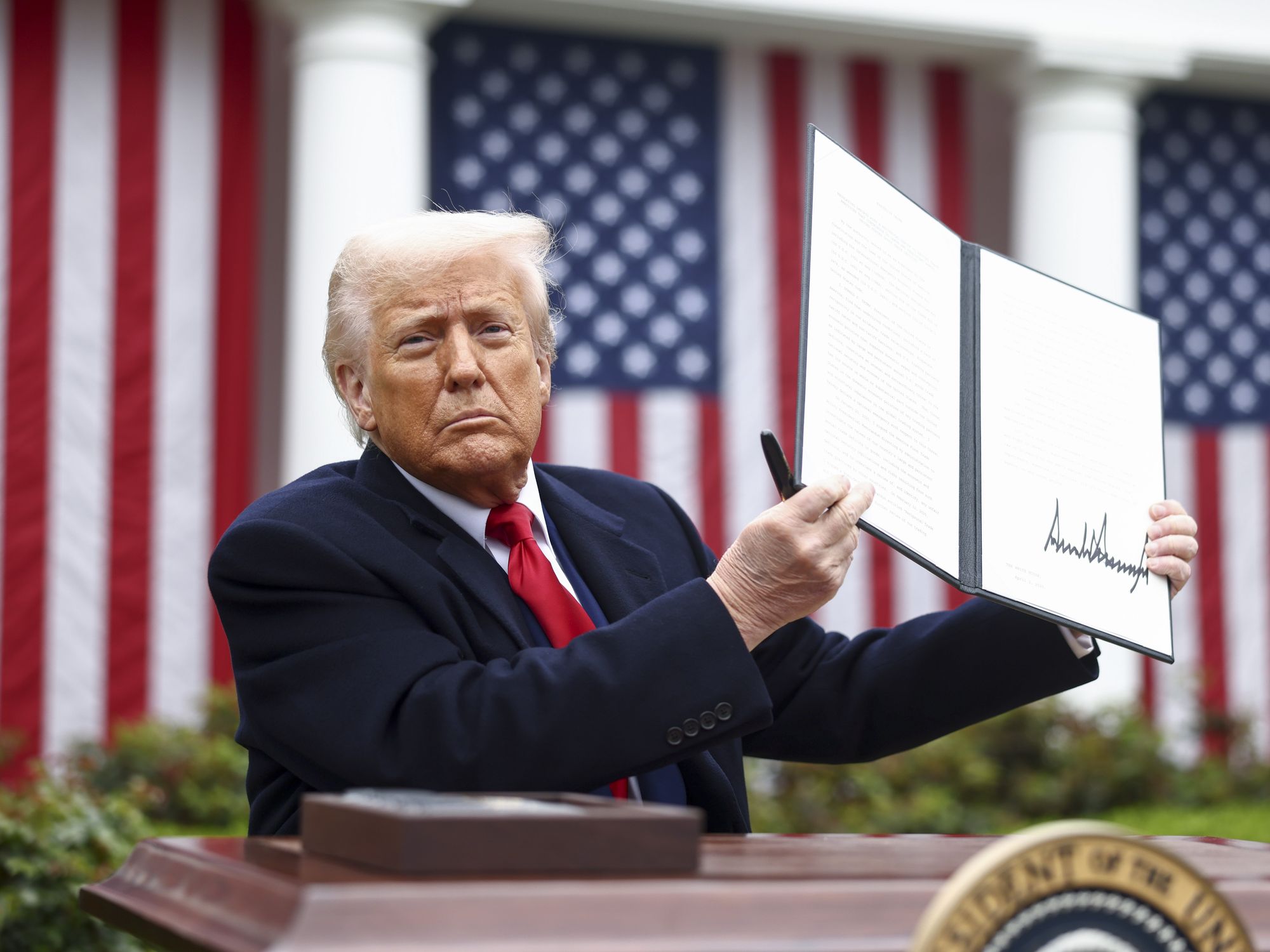 photo of Trump holding up tariff executive order