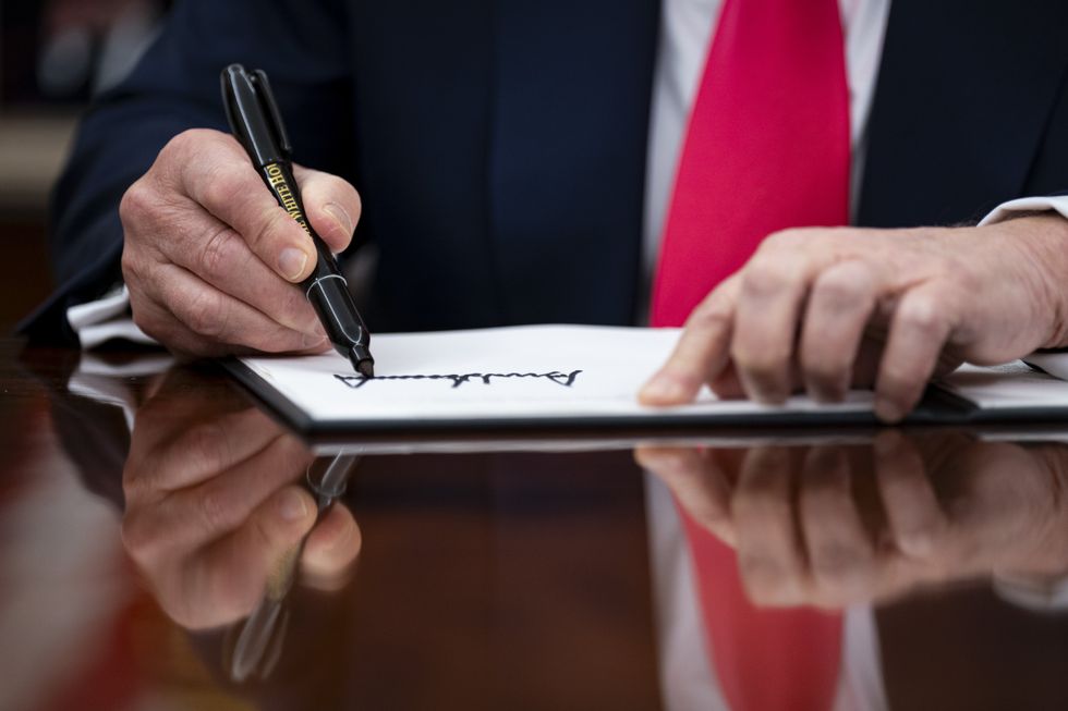 photo of Trump signs an executive order in the Oval Office of the White House in Washington, DC, US, on Thursday, March 6, 2025.