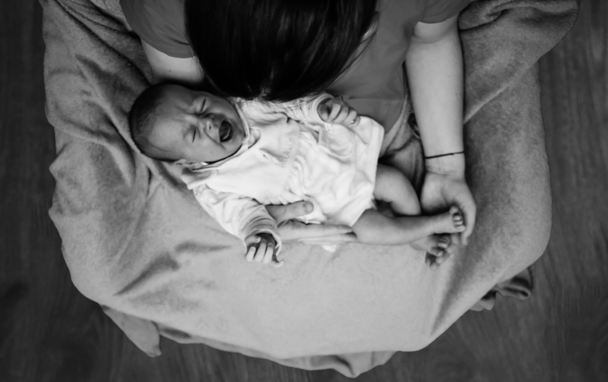 Photo of crying baby in mother's arms