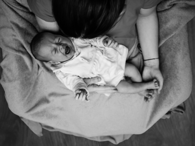 Photo of crying baby in mother's arms