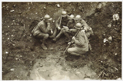 Ialian soldiers gathered to read a letter in a trench in 1917 during World War I