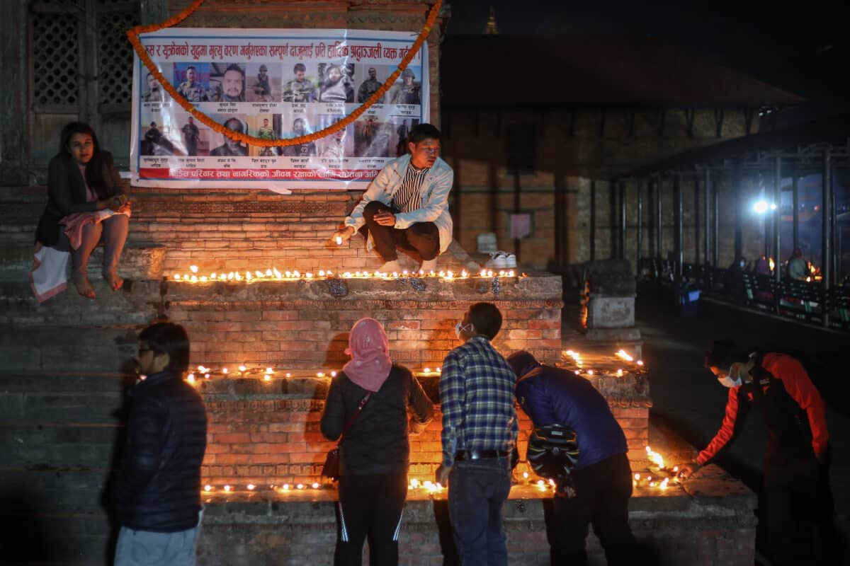 Photo of families lighting up lamps during a vigil for a deceased Nepali citizen in Russia.